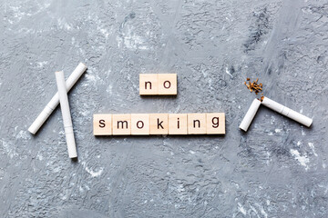 Cigarette And Wooden Blocks, Broken cigarette on table background, No Tobacco Day with hourglass,...