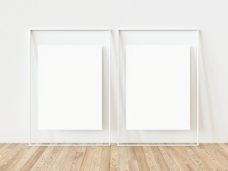 Two identical white vertical photo frames for text space on wooden floors Empty two white picture frames mockup template isolated on white wall indoors. 3d illustration