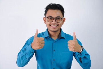 Excited cheerful asian businessman with glasses wearing blue shirt isolated over white background, showing thumbs up