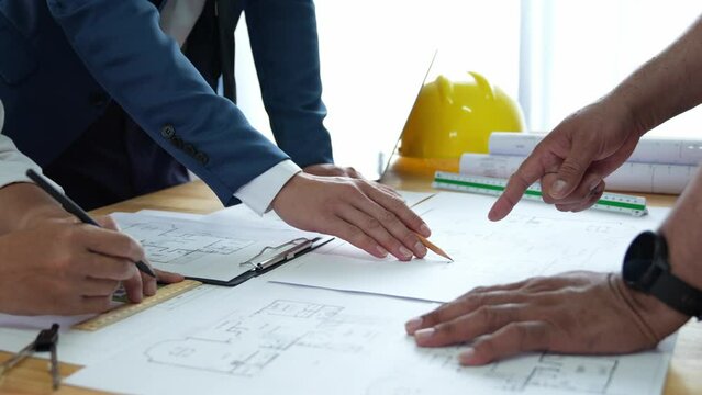 Businessman and architect meeting for planing and checking house design and house model and secretary takes notes, the architect design working drawing sketch plans blueprints