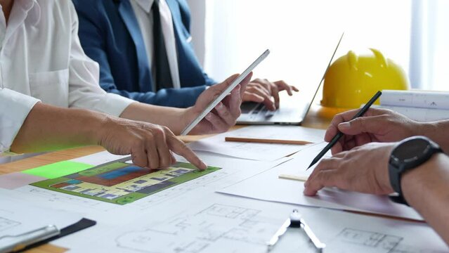 Businessman and architect meeting for planing and checking house design and house model and secretary takes notes, the architect design working drawing sketch plans blueprints