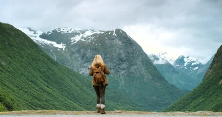Adventure, fun and freedom with a female hiker enjoying the view while hiking outdoors in nature. Rearview of a woman feeling happy, free and taking a hike while exploring on a journey of discovery