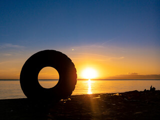 silhouette of objects on the beach with sunrise