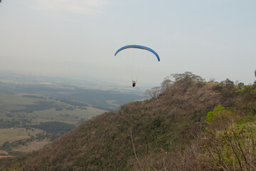 man flying a paraglider in a natural landscape