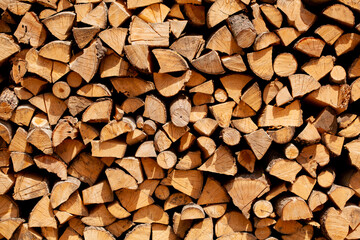 Background of stacked chopped wood logs. Pile of wood logs ready for winter.
