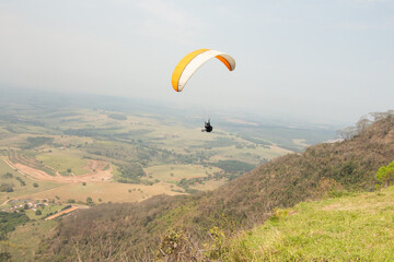 man flying a paraglider in a natural landscape