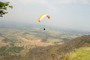 man flying a paraglider in a natural landscape