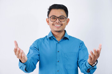 Smiling young asian businessman. with glasses in wearing blue shirt posing isolated on white background. Achievement career wealth business concept. Standing with outstretched hands