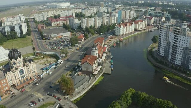 Aerial flight near the lighthouse, river, historical center with a view of a passing boat on the river and a view of modern architecture in Kaliningrad, Russia drone video