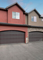 Vertical Puffy clouds at sunset Townhouse exterior with garage and sliding glass windows