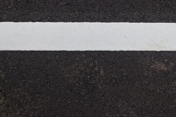 Fototapeta premium White paint line on asphalt road surface, with gray color guidel