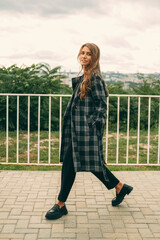 Handsome blonde woman walks on a windy weather while looking at the camera.