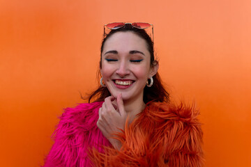 Excited happy young woman posing isolated over orange wall background