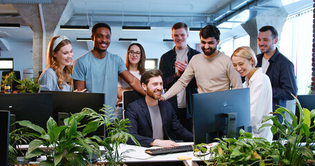 Caucasian man introducing ideas to team of startup project. IT company. Cheerful males and females,...