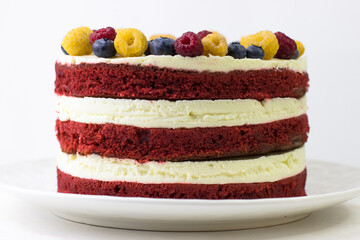 Cake is red velvet on a white background. Side view