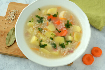 Krupnik, traditional Polish barley soup with vegetables in a bowl