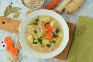 Krupnik, traditional Polish barley soup with vegetables in a bowl