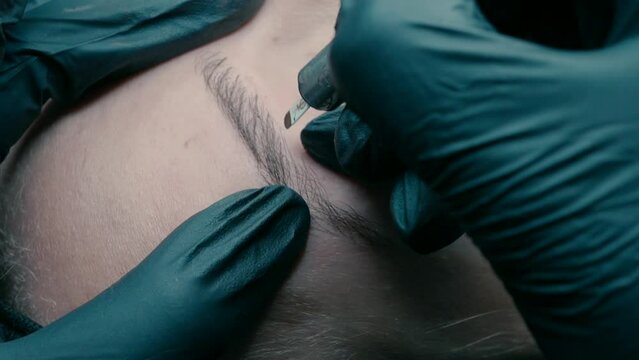 Video recording of microblading work. Permanent makeup on the eyebrows for a young woman.