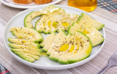 ripe avocado pulp cut into pieces sprinkled with lemon juice on a plate