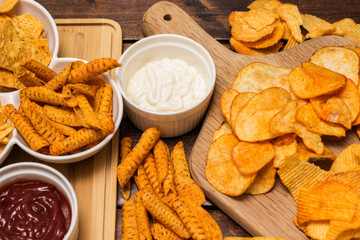 Tortilla chips on a cutting board and dipping sauce
