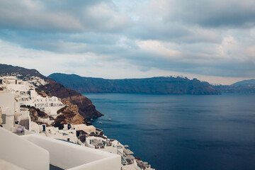 Santorini island Oia landscape. Traditional white houses on cliff with sea and mountains view. Travel to Greece.