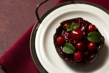 Chocolate dessert with cherries on a burgundy background