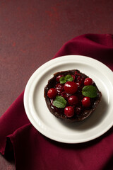 Chocolate dessert with cherries, top view