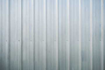 Light gray metal siding with shadows, Full frame background of shiny corrugated galvanized metal wall texture in black and white.