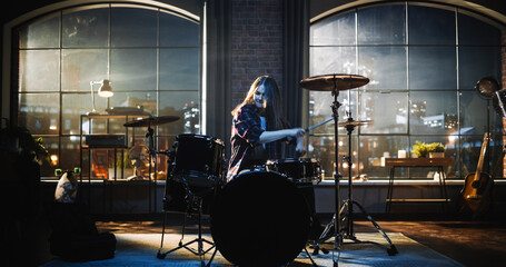 Young Female Playing Drums During a Band Rehearsal in a Loft Studio During an Evening or Night Session. Drummer Girl Practising Before a Live Concert on Big Stage with Audience.