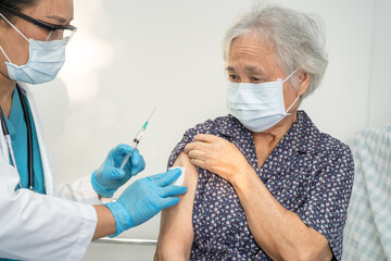 Elderly Asian senior woman wearing face mask getting covid19 or coronavirus vaccine by doctor make injection. - obrazy, fototapety, plakaty