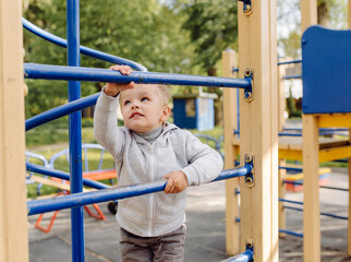 Obraz premium little boy playing on the playground outdoors