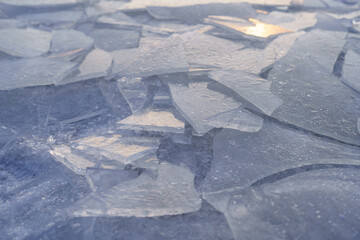 Closeup pieces of cracked ice over body of water or river frozen in cold weather after winter...