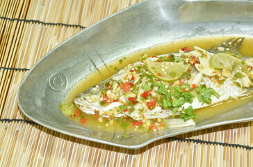 steamed bass fish dressing lemon sweet and sour chili sauce on plate 