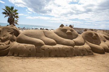 Cat made of sand on the beach. Sand sculpture of a cat in Maspalomas town Gran Canaria, Canary Islands, Spain