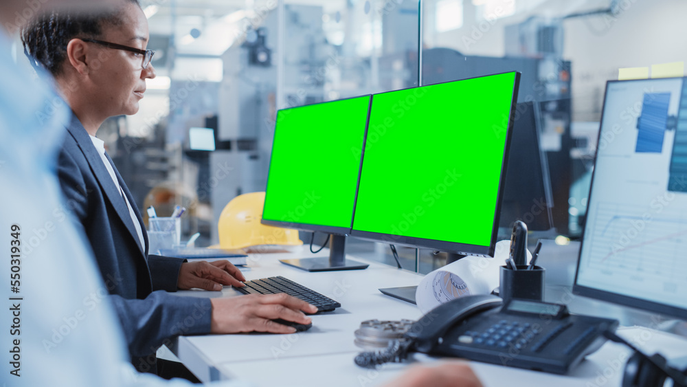 Poster Factory Office Facility: Industrial Engineers Drafting Blueprints of a Heavy Industry Machine Parts on a Computer CAD Software. One Computer Monitor Display is a Green Screen Mock Up Template.