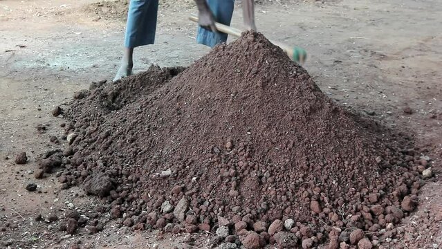 Close up of worker mixing fertile soil with spade in nursery farm
