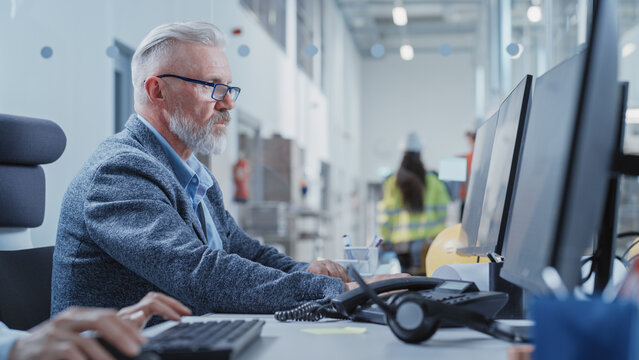 Factory Office Room: Industrial Engineer Working on Development Model of a Heavy Industry Machine Part on a Computer 3D Software. Modern Technological Industry 4.0 Research and Development Center.