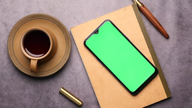 top view of smart phone and notepad on table 