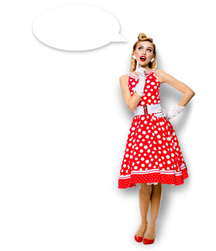 Full body length image of thinking woman in red pin up dress. Blond pinup thougthfull girl in studio, isolated white background. Empty blank speech sign bubble, having idea.