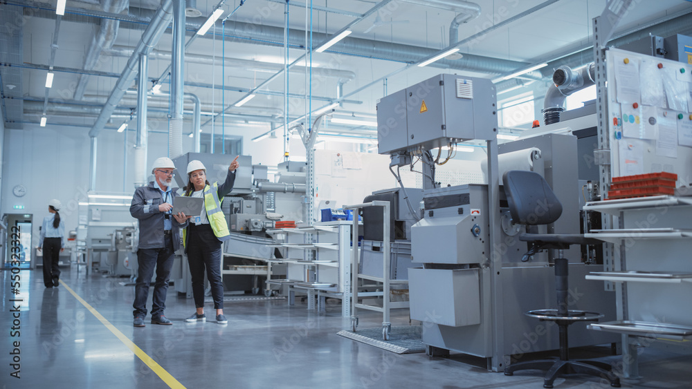 Poster two professional heavy industry colleagues in hard hats at factory. checking and discussing industri