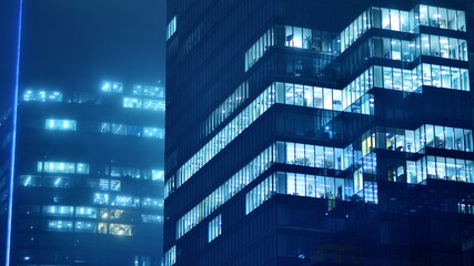 Pattern of office buildings windows illuminated at night. Glass architecture ,corporate building at...