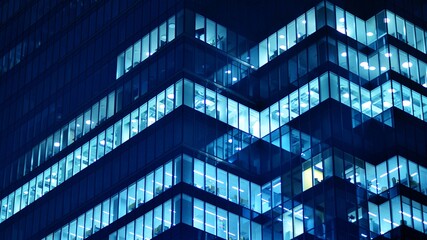Pattern of office buildings windows illuminated at night. Glass architecture ,corporate building at night - business concept. Blue graphic filter. © Grand Warszawski