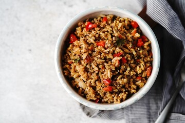 Obraz na płótnie Canvas Quinoa brown rice pulao with red pepper served in a bowl- healthy eating concept
