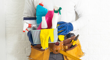 Man holding plastic bucket with brushes, gloves and detergents