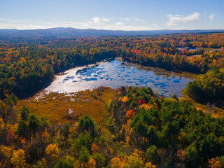 Aerial view of Marsh Pond in fall in historic town center of Chichester, New Hampshire NH, USA. 