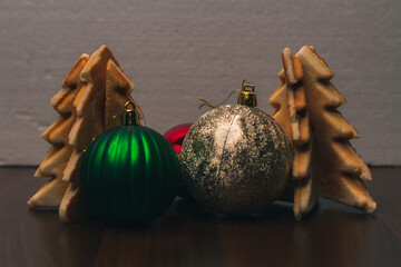 Gingerbread in the form of Christmas trees and Christmas ornaments. New Year. Home decoration for winter holidays. Merry Christmas. Branches of Christmas trees. Symbols of December