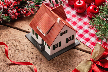 Miniature house and Christmas decoration background with space for text. Concept of real estate...