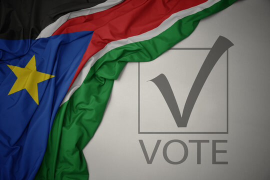 waving colorful national flag of south sudan on a gray background with text vote. 3D illustration