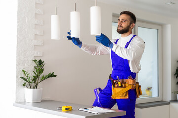 electrician installing led light bulbs in ceiling lamp