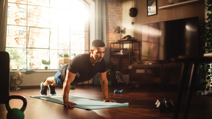 Fototapeta premium Strong Athletic Black Man Does Workout at Home Gym, Doing Push Ups. Lean Fit Muscular Mixed Race Sportsman Staying Healthy, Training at Home. Sweat and Determination. Wide Shot